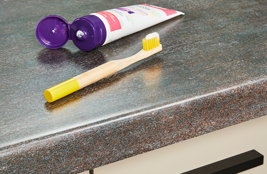 Formica laminate bathroom countertop and cabinet with toothbrush and toothpaste