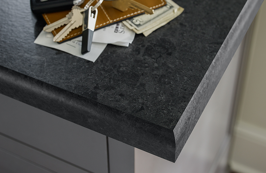 Close-up of black Formica laminate countertop edge with wallet and keys