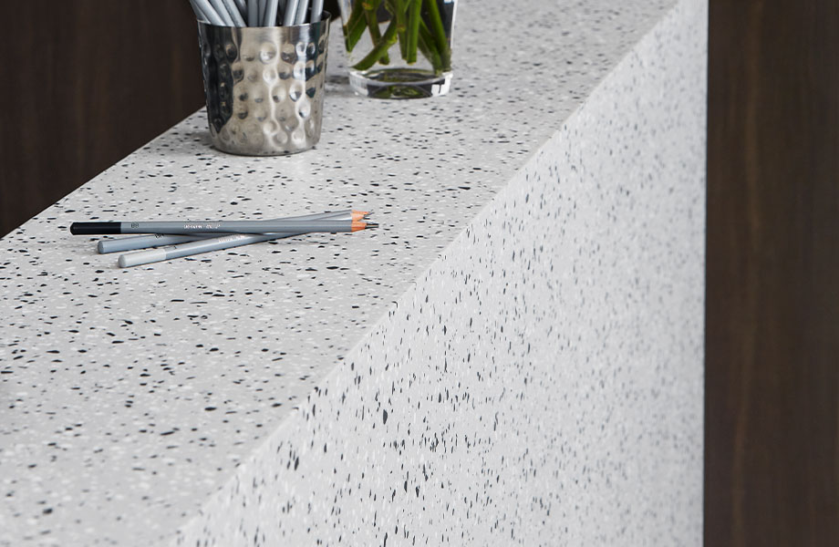 410 Argento Terrazzo Matrix front desk with pencils and flowers 5796 NG Graphite Elm wall